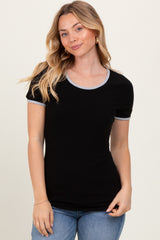 woman wearing a black ribbed short sleeve top with gray trim and standing against a neutral background