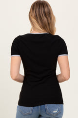 woman wearing a black short sleeve top with contrasting trim, viewed from the back, paired with light blue jeans
