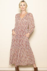 woman wearing a long sleeve floral maxi dress with a v-neck and pockets, styled with brown ankle boots