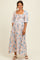 woman wearing a floral print long sleeve maternity maxi dress with a square neckline and a baby bump visible