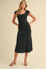woman wearing a black fitted midi dress with cap sleeves and a flared hem, posing against a neutral background