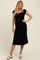 woman wearing a black maternity dress with cap sleeves and a flowing skirt, showing her baby bump