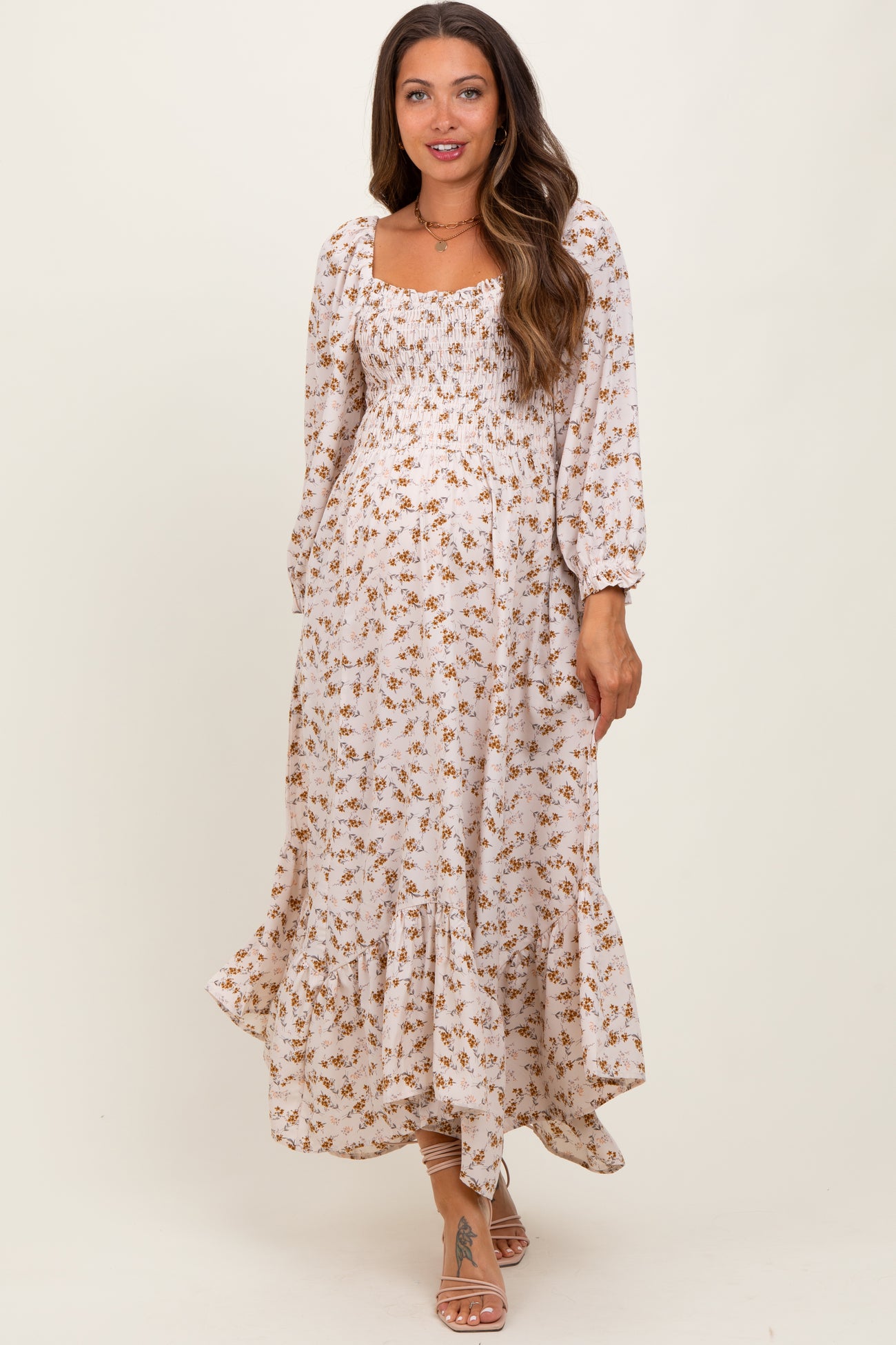 woman wearing a floral maternity maxi dress with puff sleeves and a ruffled hem