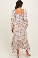 woman wearing a floral print long sleeve maternity dress with a square neckline and ruffled hem, showing a baby bump