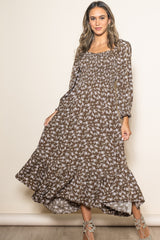 woman wearing a brown floral maxi dress with long sleeves and a tiered hemline