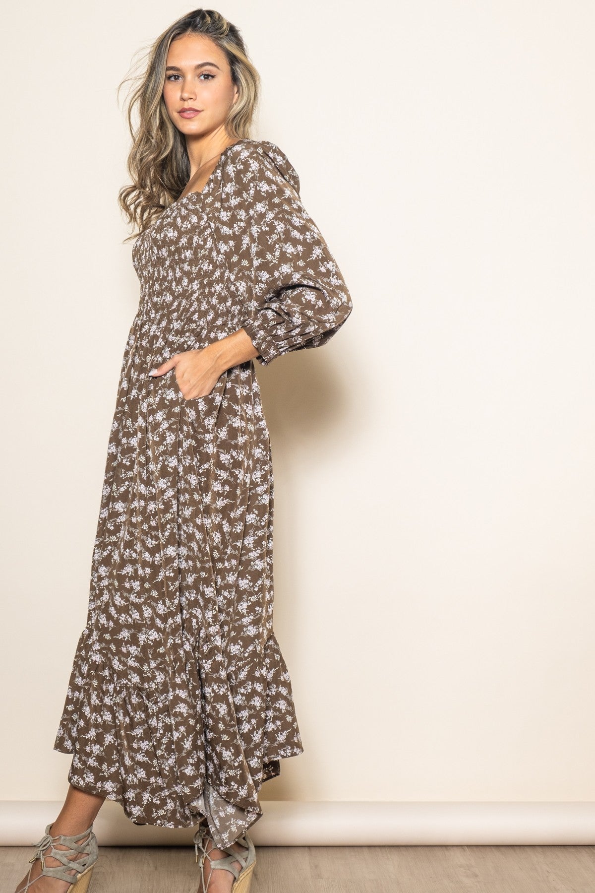 woman wearing a brown floral maxi dress with puff sleeves and side pockets