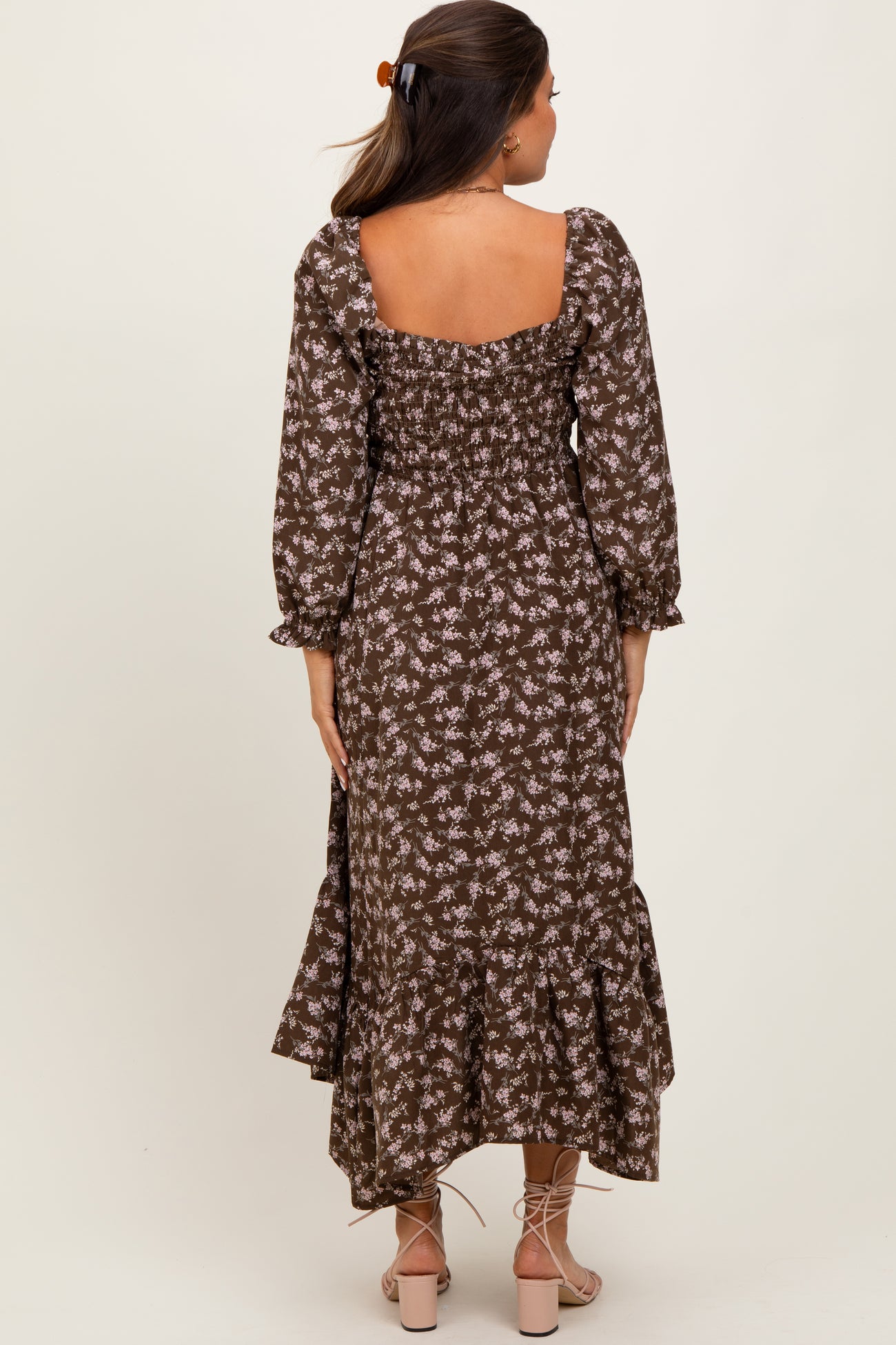 woman wearing a brown floral maternity maxi dress with a smocked back and tiered hem