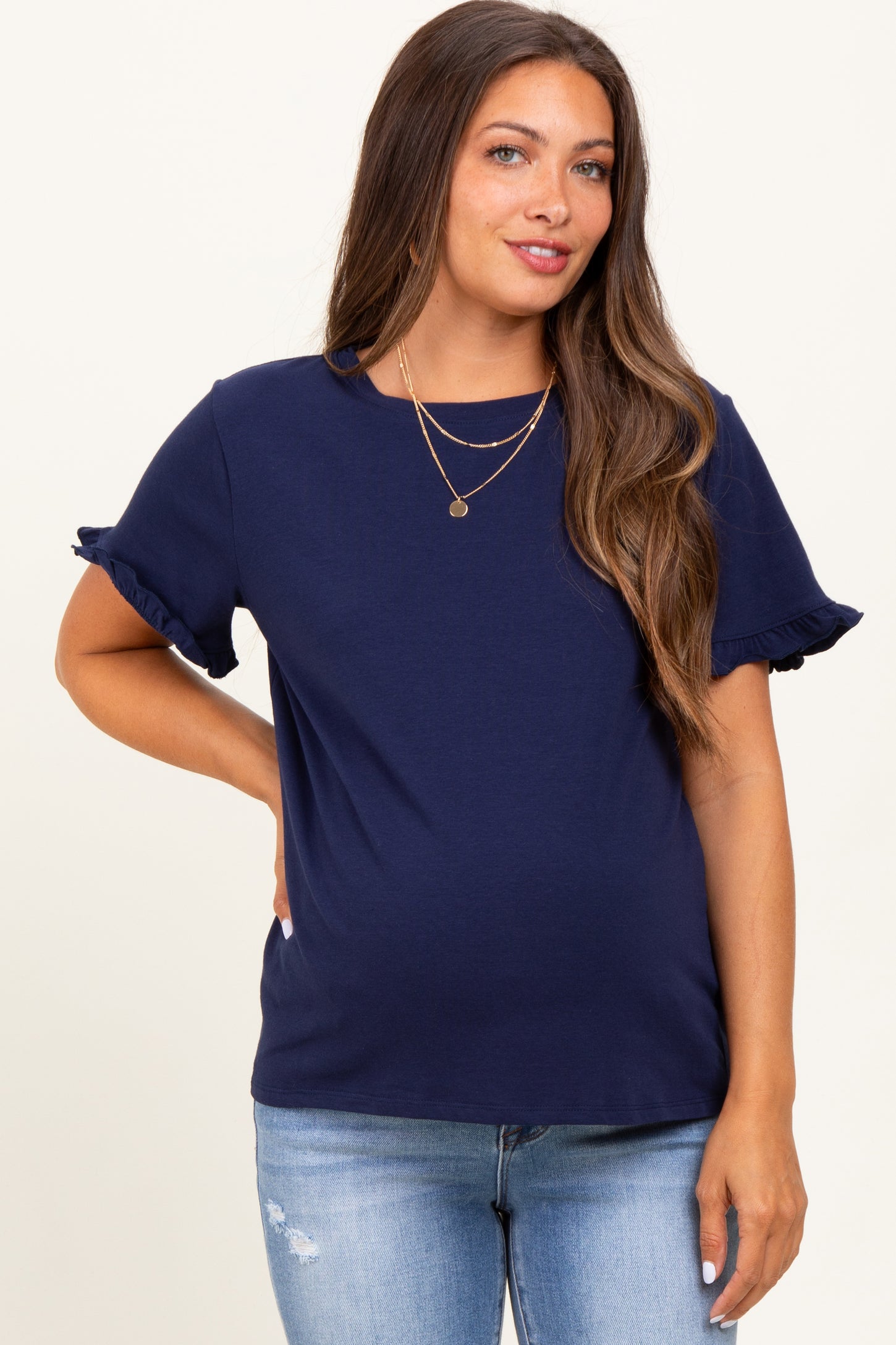 woman wearing a navy blue maternity top with ruffle sleeves and a visible baby bump