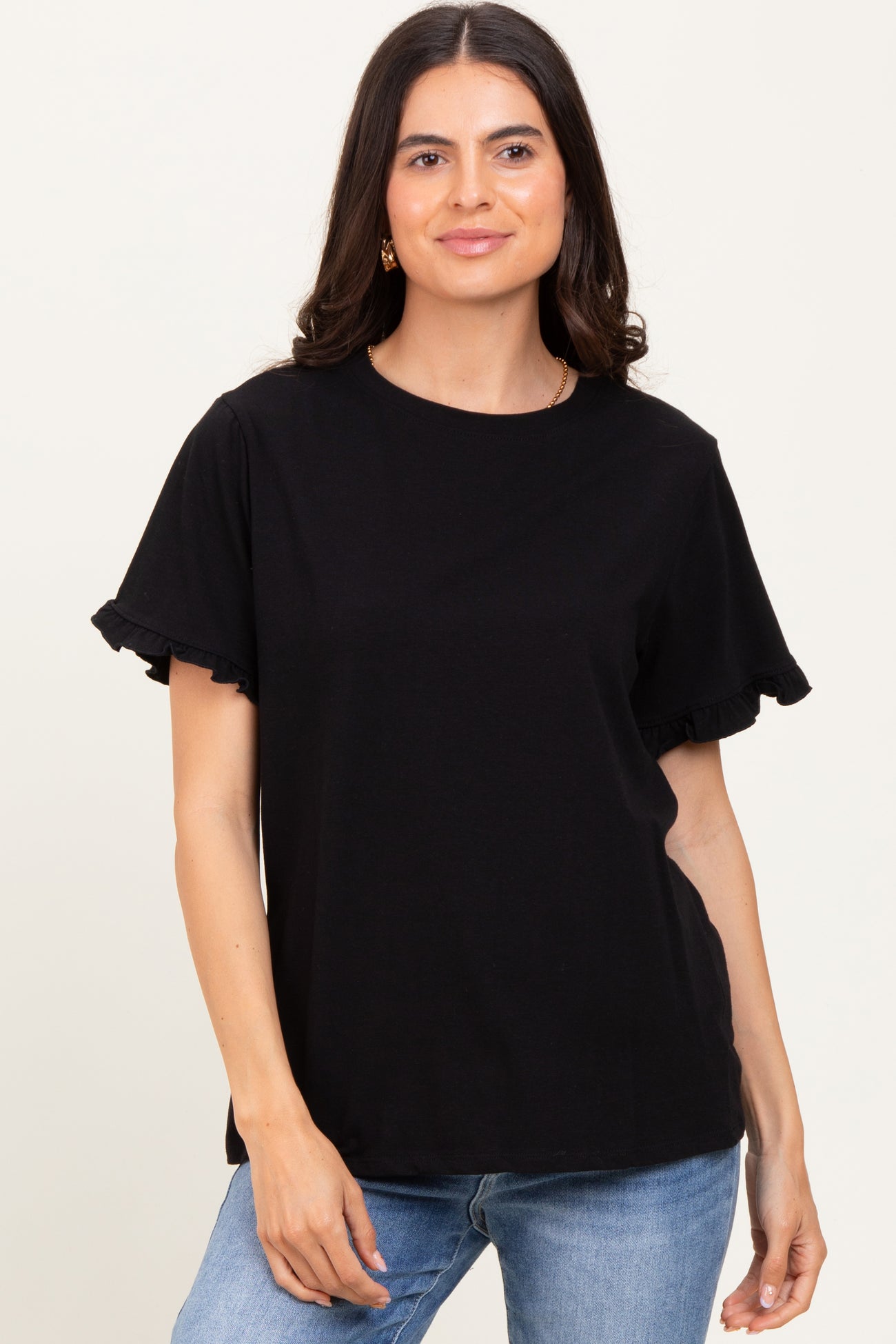 woman wearing a black t-shirt with ruffled short sleeves and a relaxed fit, paired with blue jeans