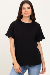 woman wearing a black t-shirt with ruffled short sleeves and a relaxed fit, paired with blue jeans
