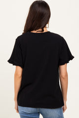 woman wearing a black t-shirt with ruffled sleeves, viewed from the back, paired with light blue jeans