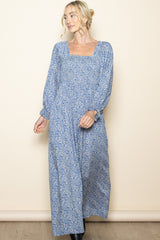 woman wearing a long blue floral maxi dress with long sleeves and a square neckline