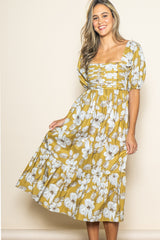 woman wearing a mustard yellow floral maxi dress with puff sleeves and tiered skirt