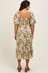 woman wearing a mustard floral maternity dress with puff sleeves and a tiered hem, showing a visible baby bump from the back
