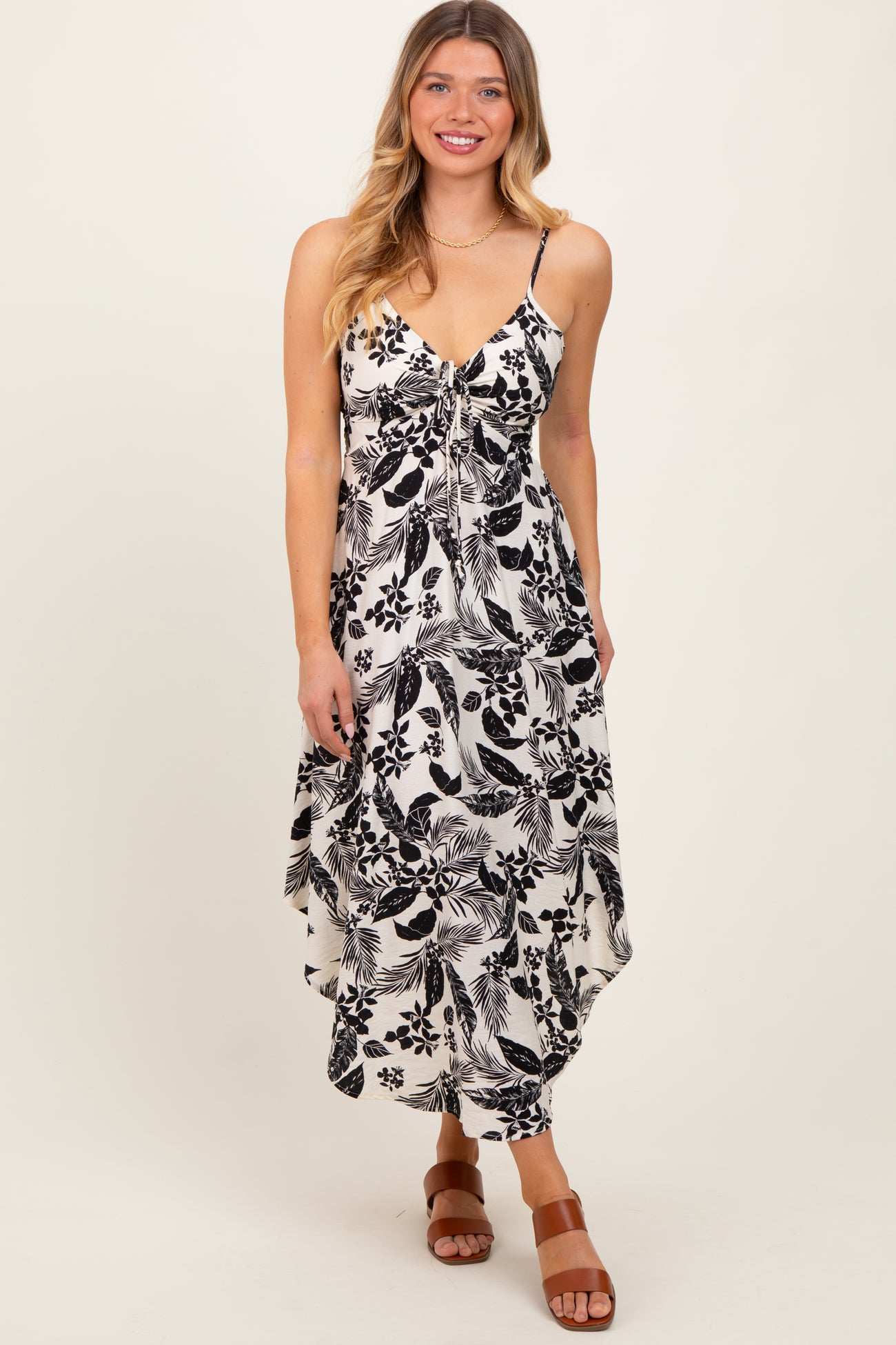 woman wearing a black and white floral print maxi dress with a v-neckline and adjustable straps