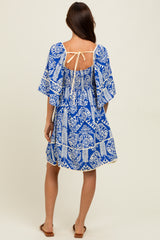 woman wearing a blue and white patterned short sleeve dress with a tie back detail and a relaxed fit