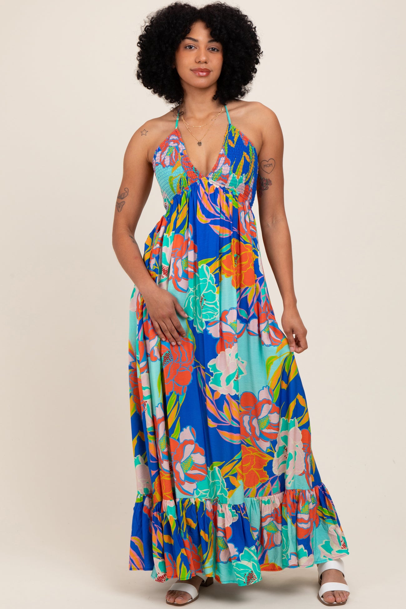 woman wearing a colorful floral maxi dress with a halter neckline and ruffled hemline