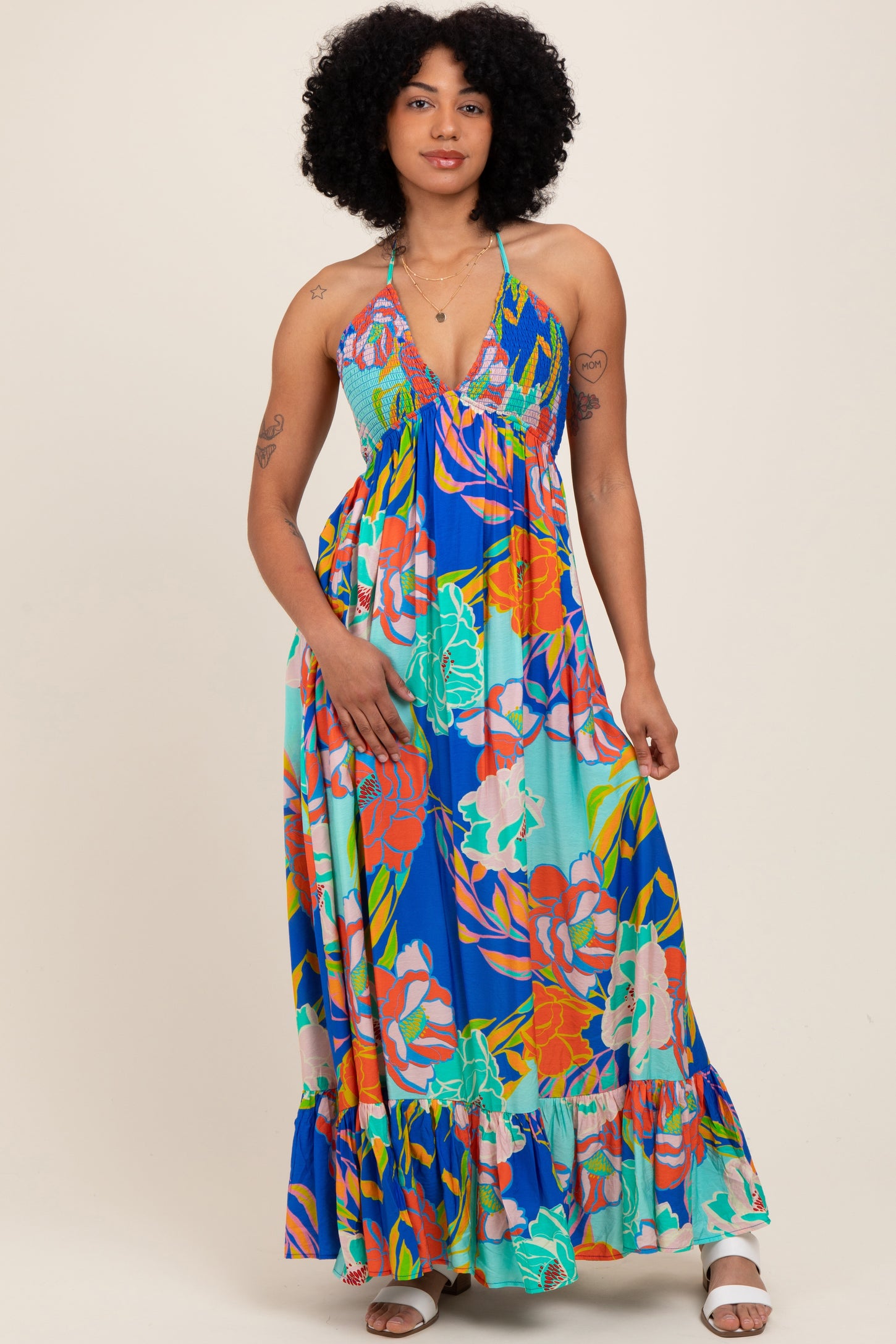woman wearing a colorful floral maxi dress with a halter neckline and ruffled hemline