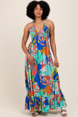 woman wearing a colorful floral maxi dress with a halter neckline and ruffled hemline