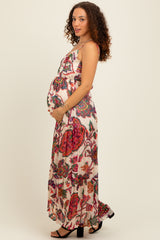 woman wearing a floral maxi maternity dress and holding her baby bump