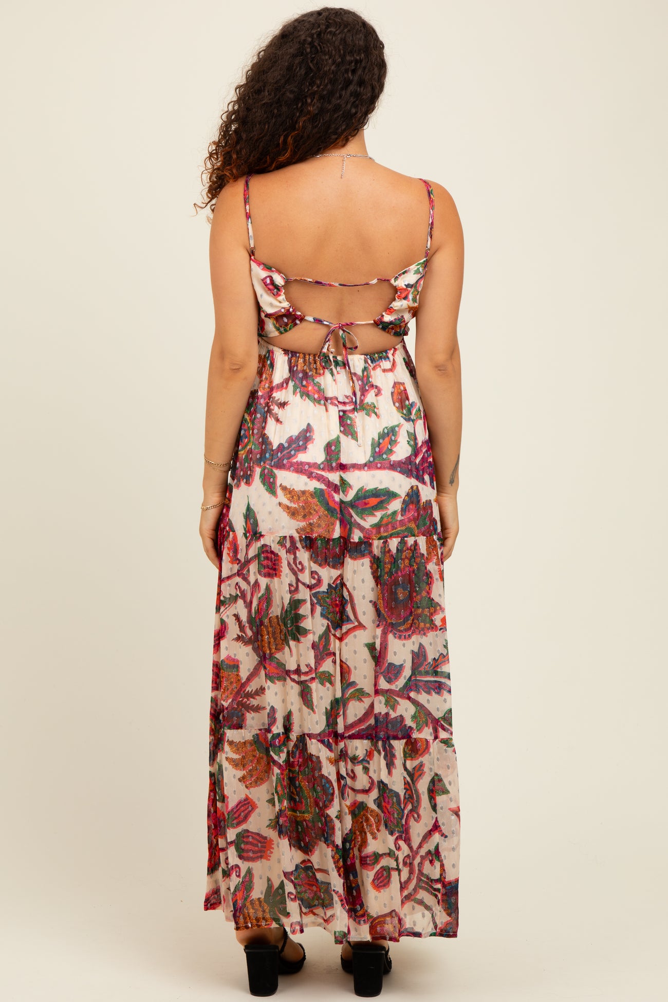 woman wearing a floral patterned maternity maxi dress with an open back design