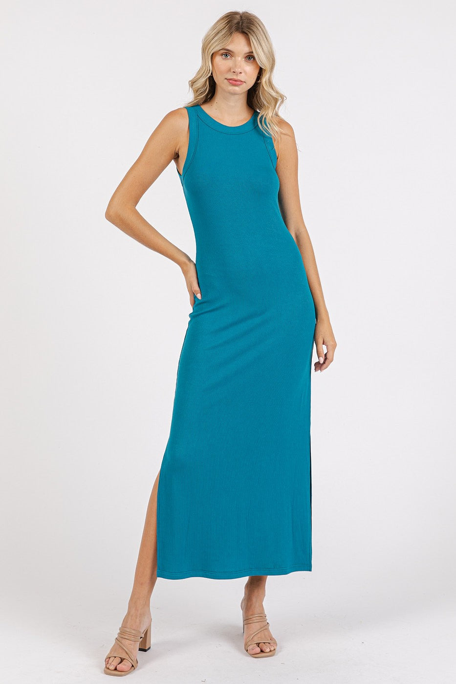 woman wearing a teal sleeveless maxi dress with a side slit and a fitted silhouette