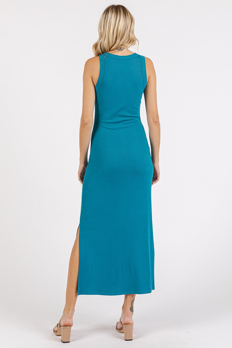 woman wearing a teal sleeveless maxi dress with a side slit, shown from the back