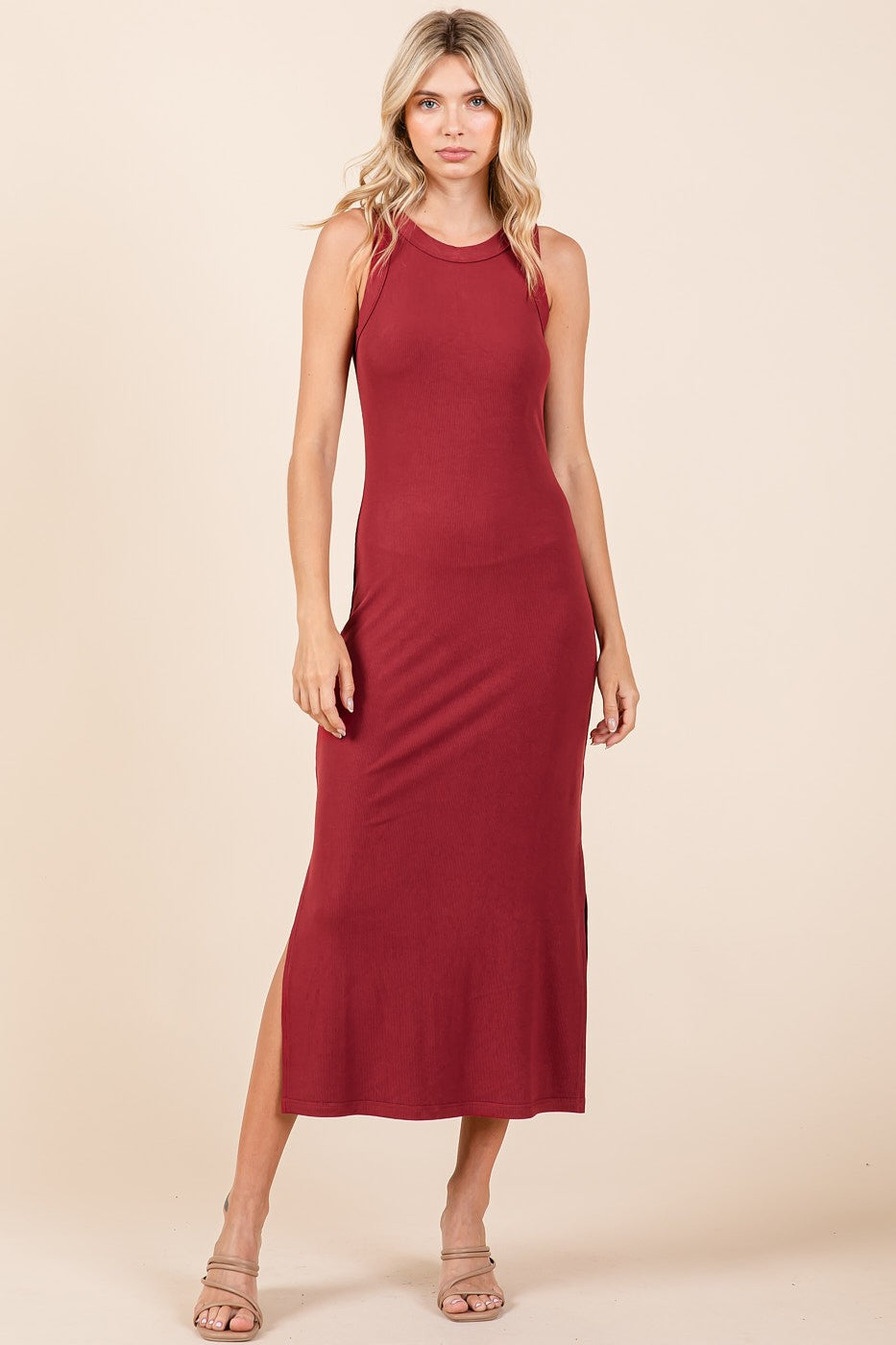 woman wearing a burgundy sleeveless maxi dress with a side slit