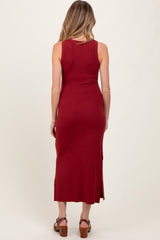 woman wearing a burgundy ribbed maternity maxi dress with side slits, seen from the back