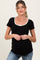 woman wearing a black maternity top with white scoop neckline and bow detail, holding her baby bump