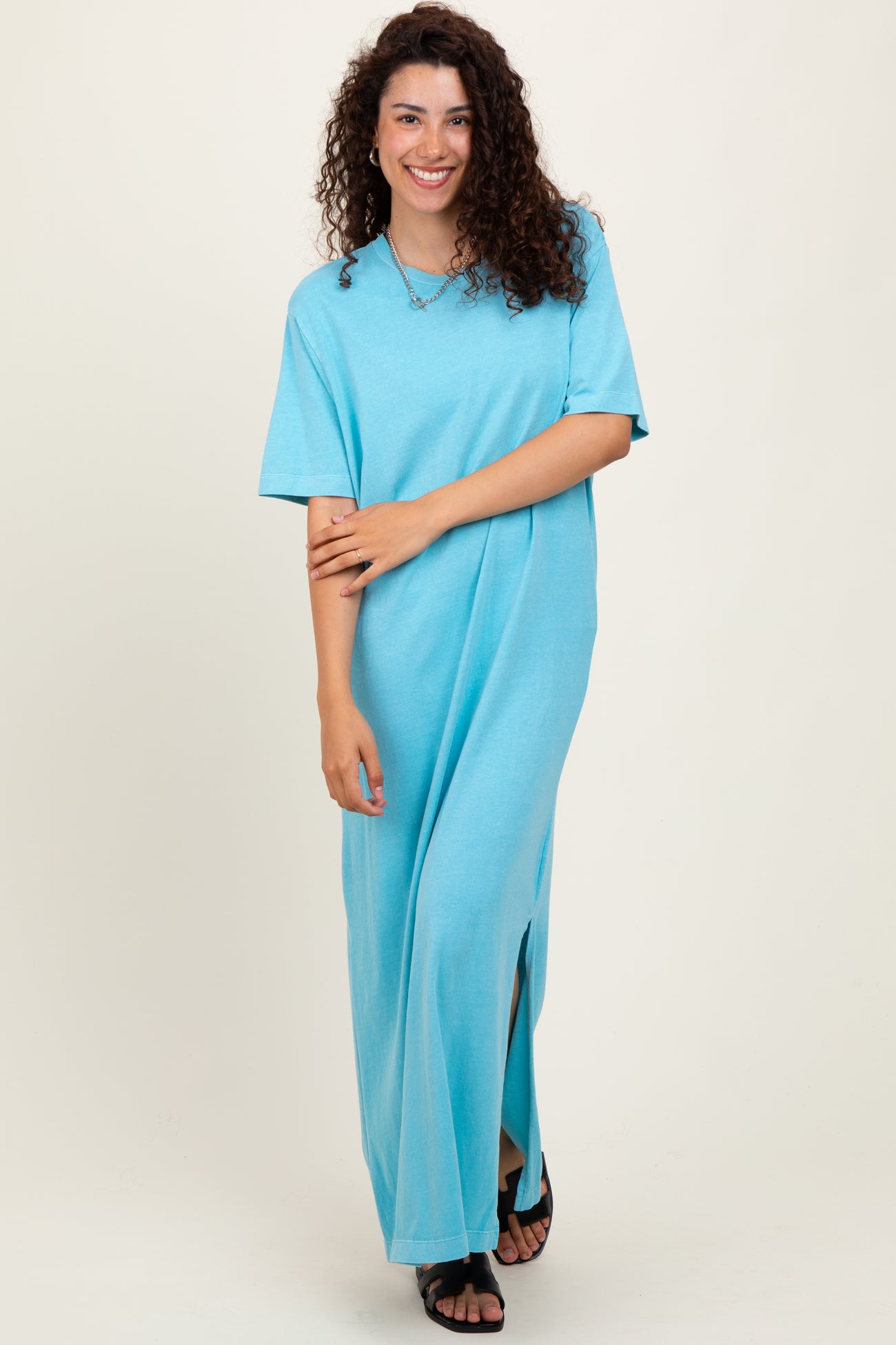 woman wearing a light blue short sleeve maxi dress with side slits and a relaxed fit