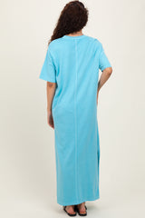 woman wearing a light blue oversized maxi dress with short sleeves and a side slit