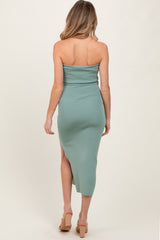 woman wearing a mint green strapless maternity dress with a side slit, showing her back