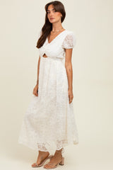 woman wearing a white lace midi dress with puff sleeves and a cut-out detail