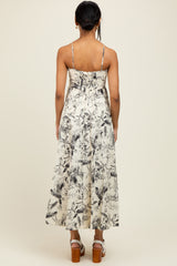woman wearing a cream floral print maxi dress with adjustable straps, viewed from the back