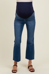woman wearing a pair of dark blue maternity jeans with a high waistband and cropped flared hem