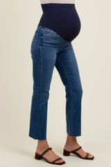 woman wearing navy blue maternity jeans with a fitted waist and cropped hem, showing her baby bump