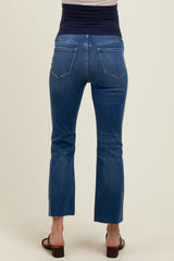 woman wearing a back view of dark wash maternity jeans with a cropped flare leg design