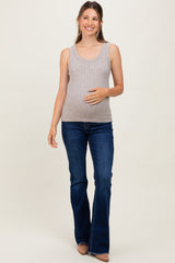 woman wearing a light gray ribbed maternity tank top and blue flared jeans, holding her baby bump