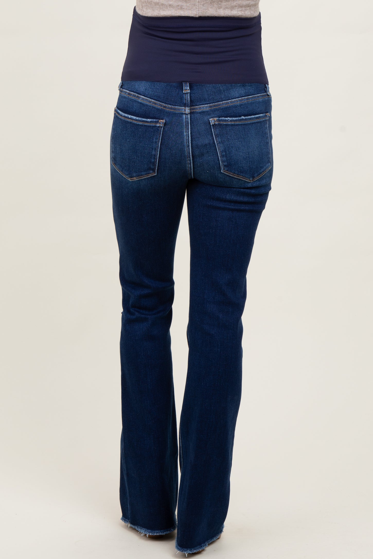 maternity wear dark blue flared jeans with a stretchy waistband shown from the back