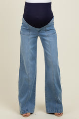 maternity wear in light blue wide leg jeans with a dark blue over-the-bump panel, model standing with bare feet