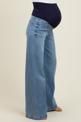 woman wearing light blue wide-leg maternity jeans with a dark blue waistband and visible baby bump