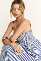 woman wearing a blue and white striped sundress with a smocked bodice and spaghetti straps