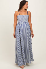 woman wearing a navy and white striped maternity maxi dress with a smocked bodice and adjustable straps, showing a baby bump