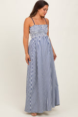 woman wearing a navy and white striped maternity maxi dress with smocked bodice and adjustable straps