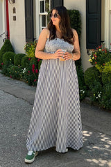woman wearing a black and white striped maternity maxi dress with a visible baby bump and green sneakers