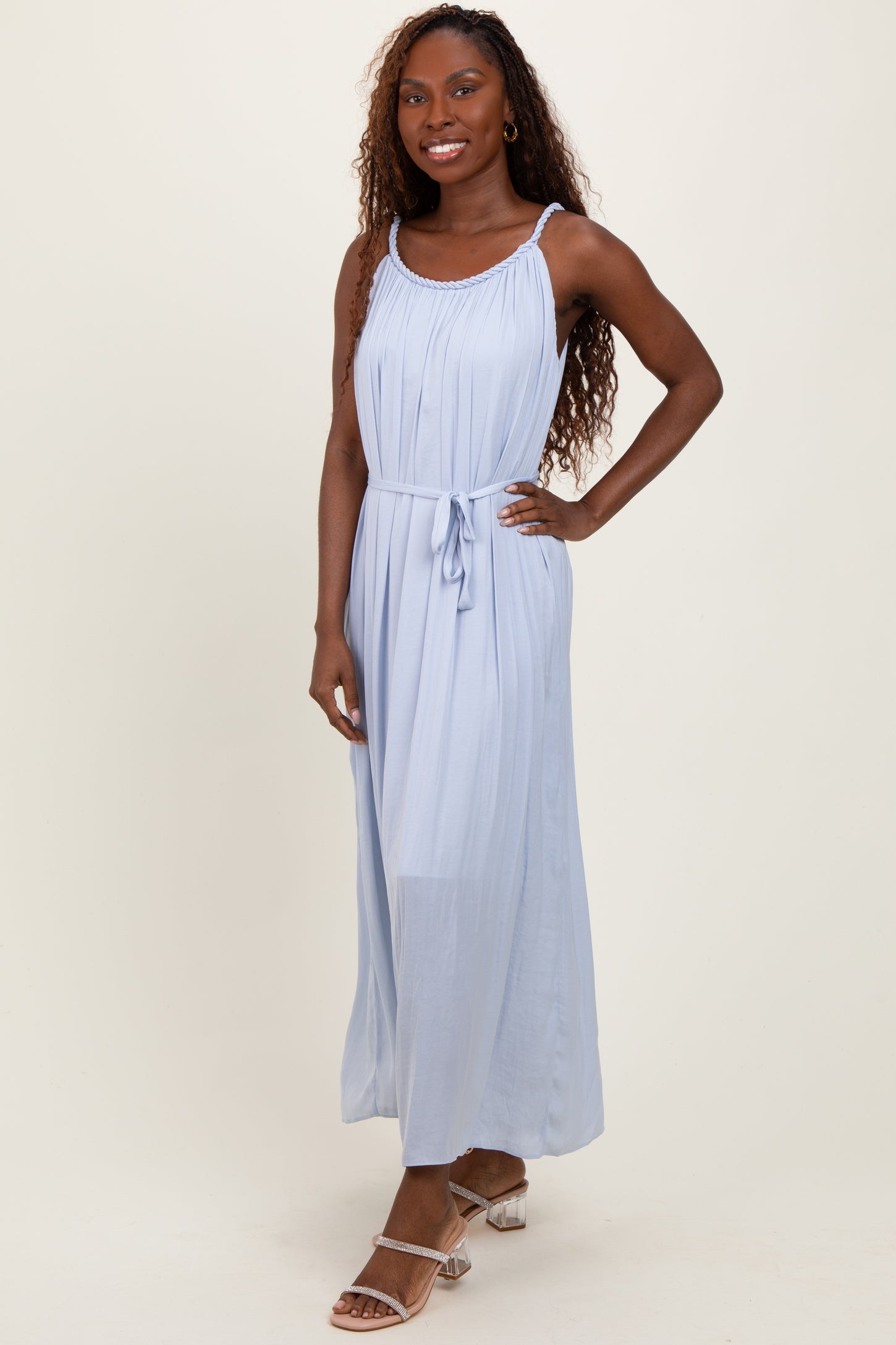 woman wearing a light blue maxi dress with a cinched waist and adjustable straps
