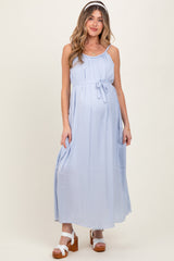 woman wearing a light blue maternity maxi dress with a tie waist and showing her baby bump
