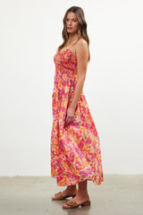 woman wearing a pink floral maxi dress with spaghetti straps and a smocked bodice