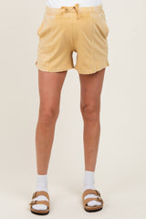 woman wearing yellow maternity shorts with a drawstring waist and side pockets